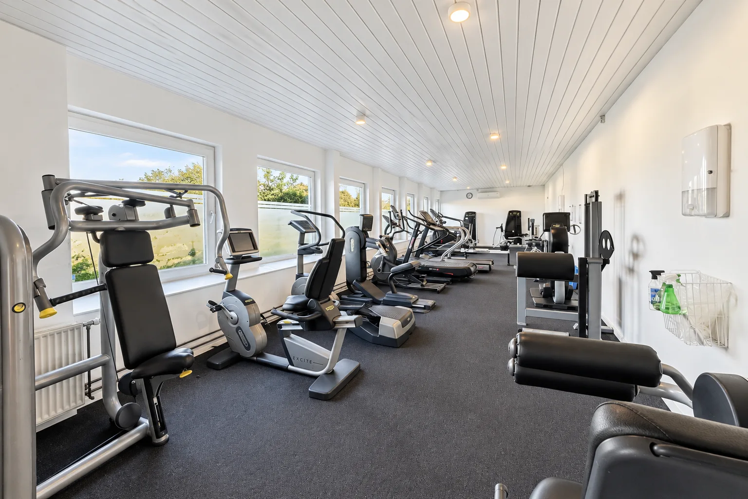 Lyse træningslokaler i Grimstrup Fitness med motionscykler, løbebånd og styrkemaskiner